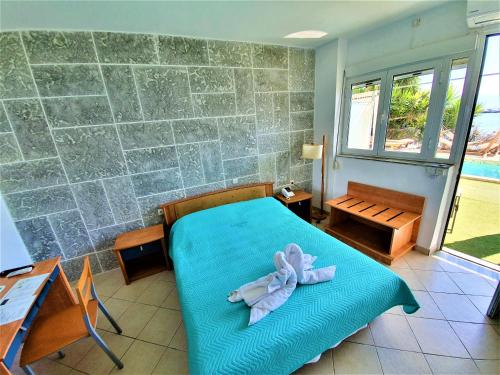a bedroom with a bed with a towel on it at Porto Evia Boutique Hotel in Amarinthos