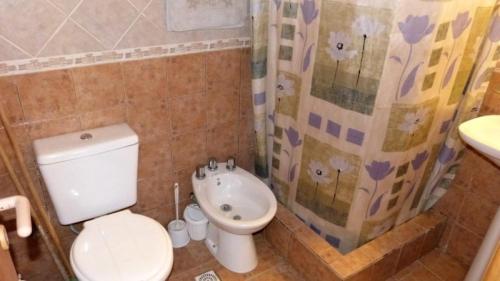 y baño con aseo, lavabo y ducha. en Complejo Valparaiso en Santa Clara del Mar