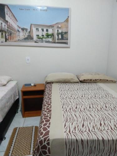 um quarto com duas camas e uma foto na parede em Pousada Jatobá em Barreirinhas