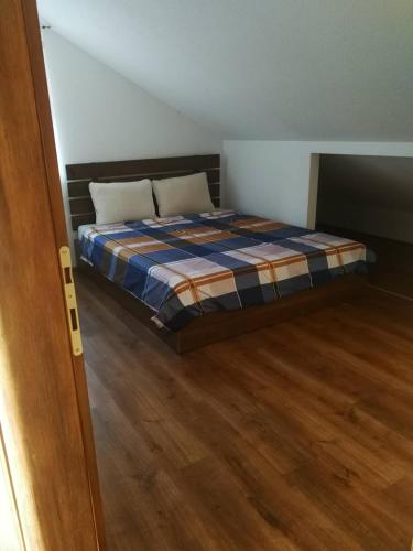 a bedroom with a bed and a wooden floor at Gold Apartment in Strumica