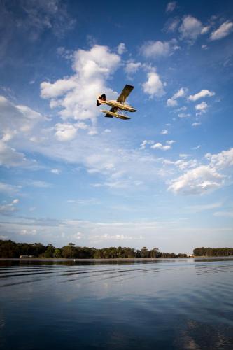 a small plane flying over a large body of water at The Seabird in Moruya