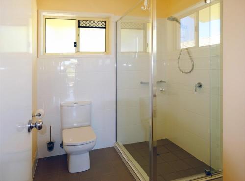 a bathroom with a toilet and a glass shower at At Cylinder Unit 3 in Point Lookout