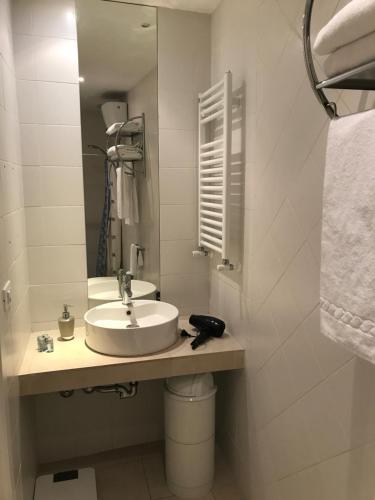 a white bathroom with a sink and a mirror at Charming 25 Apartment in Rome