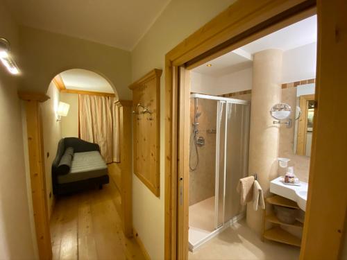 a bathroom with a walk in shower and a sink at Boutique Hotel Diana in Madonna di Campiglio