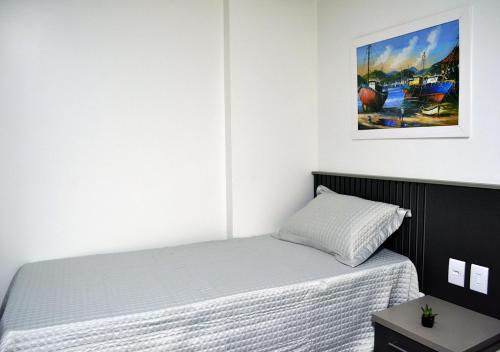 - une chambre dotée d'un lit avec une photo sur le mur dans l'établissement Suíte Privilegiada no Centro - Golden Dolphin, à Caldas Novas