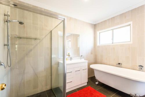 a bathroom with a shower and a tub and a sink at Mason Winery in Mount Tamborine