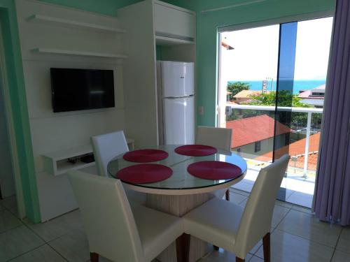 comedor con mesa, sillas y ventana en Residencial Fagundes, en Florianópolis