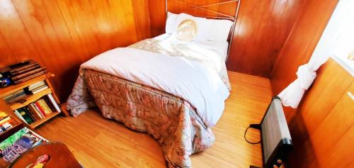 a small bedroom with a bed with white sheets at Time Traveler Retreat in Julian