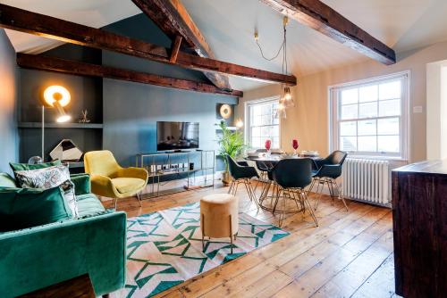 uma sala de estar com mesa e cadeiras em ARCORE Premium Rental Grafton Way em Londres