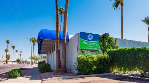 a sign for a subway station next to palm trees at SureStay Hotel by Best Western Phoenix Airport in Phoenix