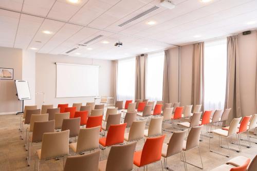 a lecture room with chairs and a whiteboard at Best Western Plus Paris Saclay in Saclay