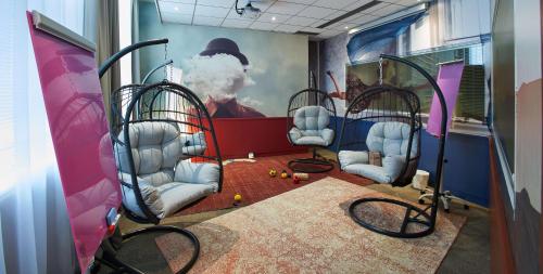 a bus with chairs and a painting on the wall at Best Western Plus Paris Saclay in Saclay