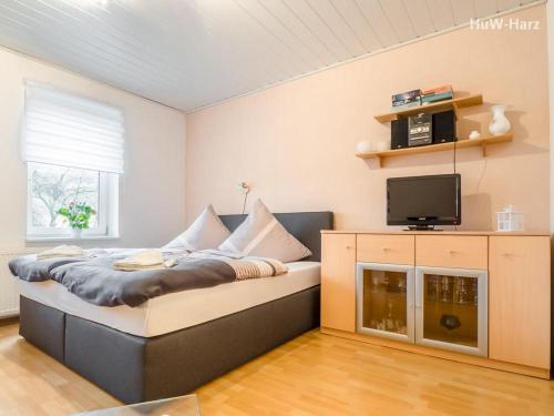 ヴェルニゲローデにあるRuhiges Apartment am Waldrand mit Schlossblickのベッドルーム(ベッド1台、テレビ付)