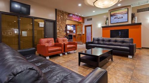 a lobby with couches and chairs and a fireplace at Seven Oaks Hotel Regina in Regina