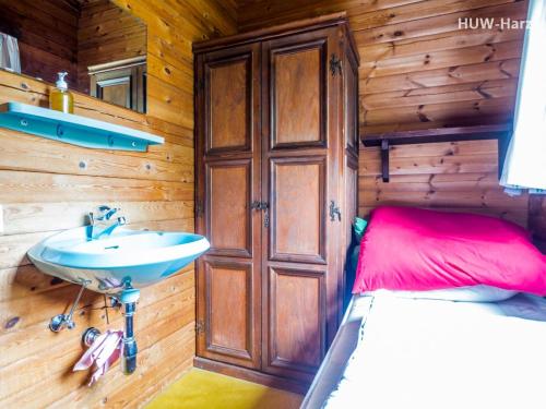 un bagno con lavandino e un letto in una cabina di Haus am Hang a Bad Lauterberg