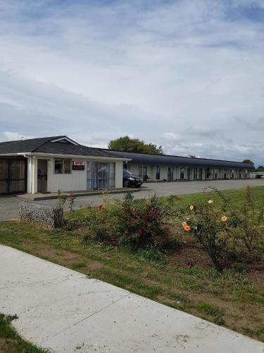 un edificio con un parcheggio e fiori di fronte di castletown motel a Foxton