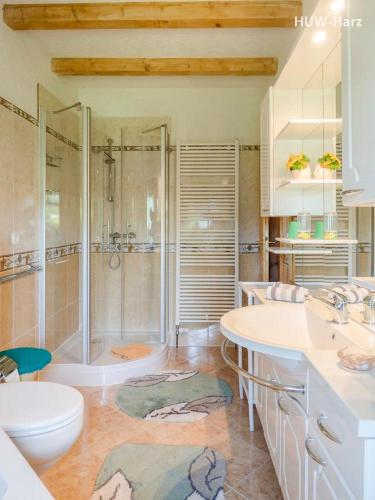 a bathroom with a shower and two sinks and a tub at Idyllisches Ferienhaus bei Wernigerode in Benzingerode