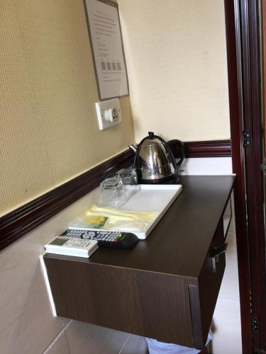 een tafel met een theepot en een telefoon erop bij Hang Ho Hostel in Hong Kong