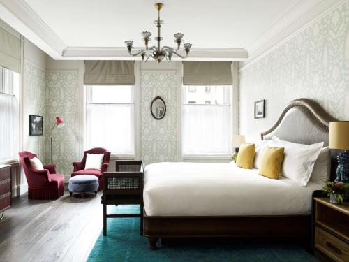 a bedroom with a large white bed and a chair at The Beekman, a Thompson Hotel, part of Hyatt in New York