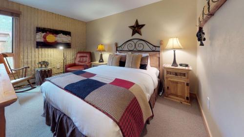 1 dormitorio con 1 cama grande y 1 silla en Vail 21 - CoralTree Residence Collection, en Vail
