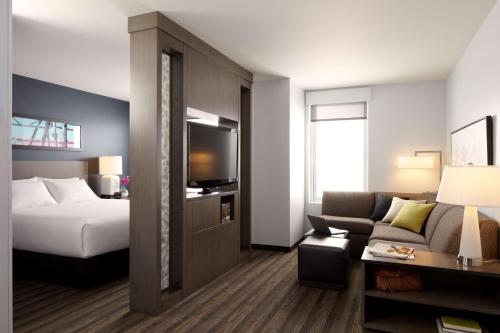 a hotel room with a bed and a couch at Hyatt House Indianapolis Fishers in Fishers