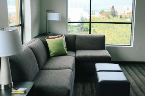 a living room with a gray couch with a green pillow at Hyatt House Indianapolis Fishers in Fishers