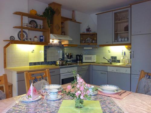 a kitchen with a table with flowers on it at Ferienwohnung Anna Zechner in Flattach