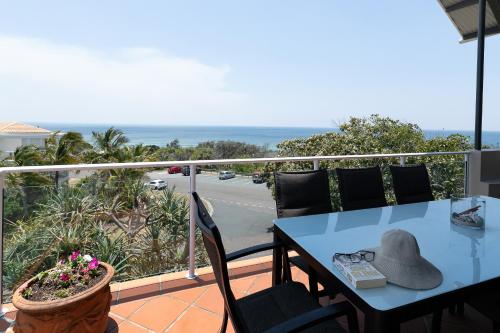 a table and chairs on a balcony with a view at Aqua Promenade Beachfront Holiday Apartments in Sunrise Beach