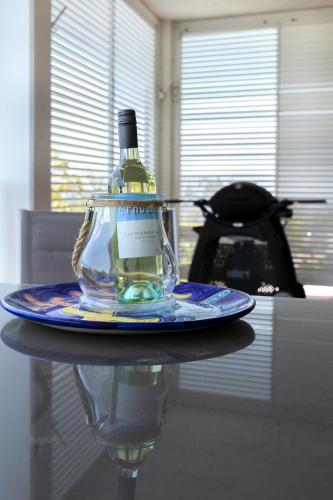 a bottle of alcohol sitting on a plate on a table at Aqua Promenade Beachfront Holiday Apartments in Sunrise Beach
