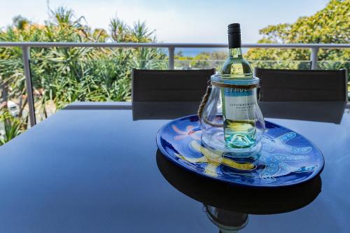 a bottle of wine sitting on top of a table at Aqua Promenade Beachfront Holiday Apartments in Sunrise Beach