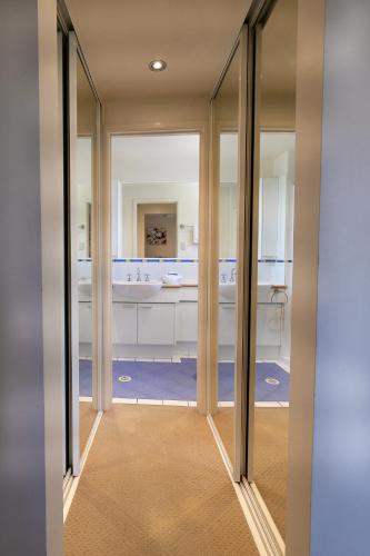 a hallway with sliding glass doors leading into a bathroom at Aqua Promenade Beachfront Holiday Apartments in Sunrise Beach
