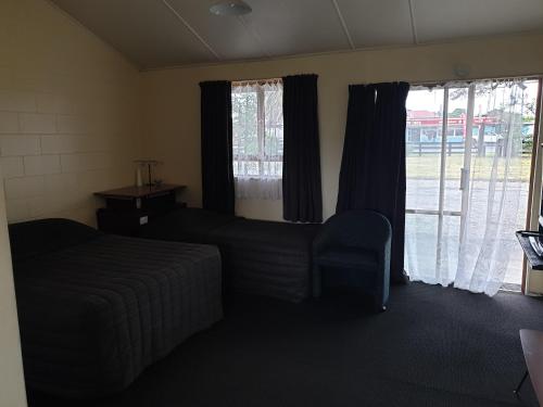 una camera con letto, divano e finestre di castletown motel a Foxton