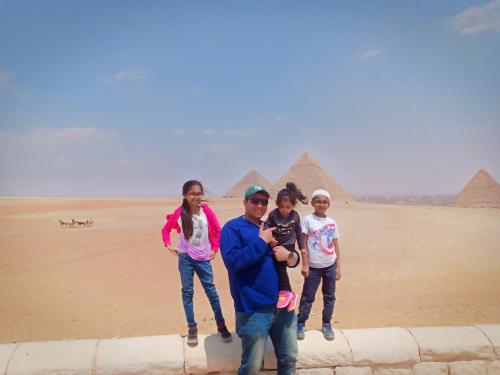 a group of people standing in front of the pyramids at Sooly pyramids Inn in Cairo