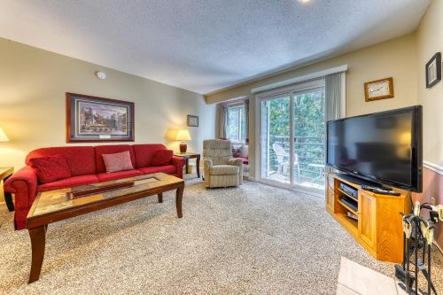 un soggiorno con divano rosso e TV a schermo piatto di Gatlinburg Summit Woods Condo a Gatlinburg