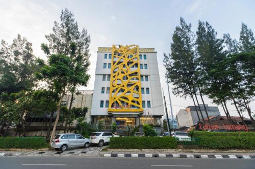 un edificio blanco con un letrero amarillo. en Royal City Hotel Jakarta, en Yakarta