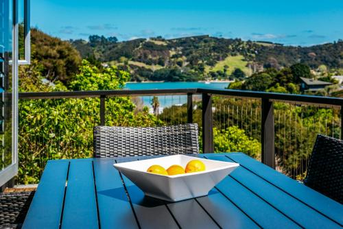 a bowl of oranges sitting on a table on a balcony at Te Kohanga, Oneroa in Oneroa