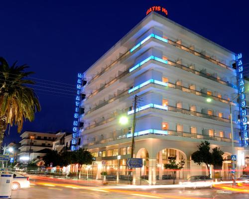 a white building with blue lights on the side of it at Maniatis Hotel in Sparti