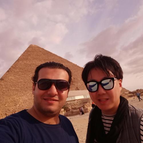 a man and a woman standing in front of the pyramid at Sooly pyramids Inn in Cairo