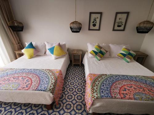 two beds sitting next to each other in a room at Apolonia Boutique in Guaduas