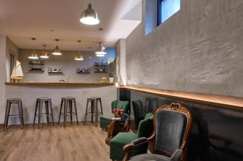 a bar with green chairs and a counter at La Via del Porto Charme Rooms in Agropoli