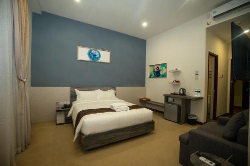 um quarto de hotel com uma cama e um sofá em Green Rose Hotel em Batam Center