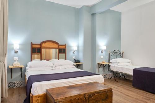 two beds in a room with blue walls at La Via del Porto Charme Rooms in Agropoli