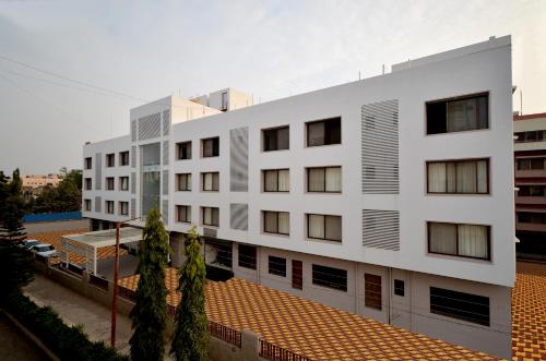 a white building with a red roof at Hotel Dwarka Park in Shirdi