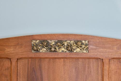 a wooden cabinet with a brass decoration on top of it at La Via del Porto Charme Rooms in Agropoli