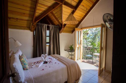 een slaapkamer met een bed en een groot raam bij Hotel Rancho Constanza & Cabañas de la Montaña in Constanza