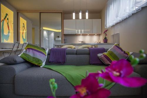 sala de estar con sofá y almohadas moradas y verdes en Apartament Ceprówka, en Zakopane
