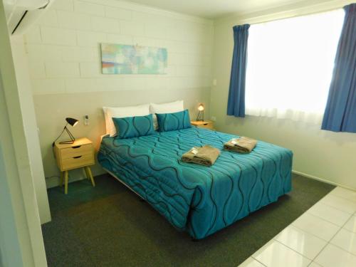 a bedroom with a blue bed and a window at Hatton Vale Motel in Hatton Vale