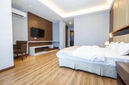 a bedroom with a large bed and a television at Lintas Platinum Hotel in Kota Kinabalu