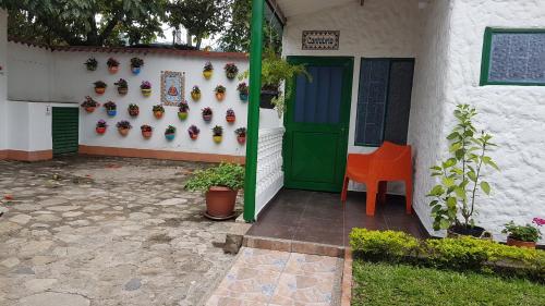 a house with a green door and a orange chair at Villa Apolonia in Guaduas