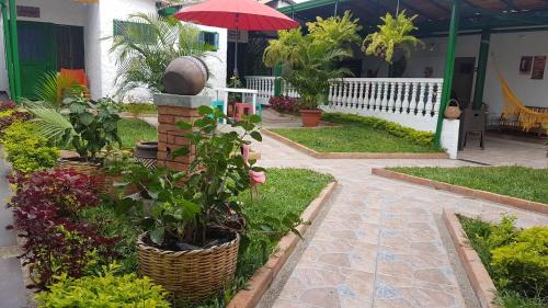a garden with a red umbrella and some plants at Villa Apolonia in Guaduas